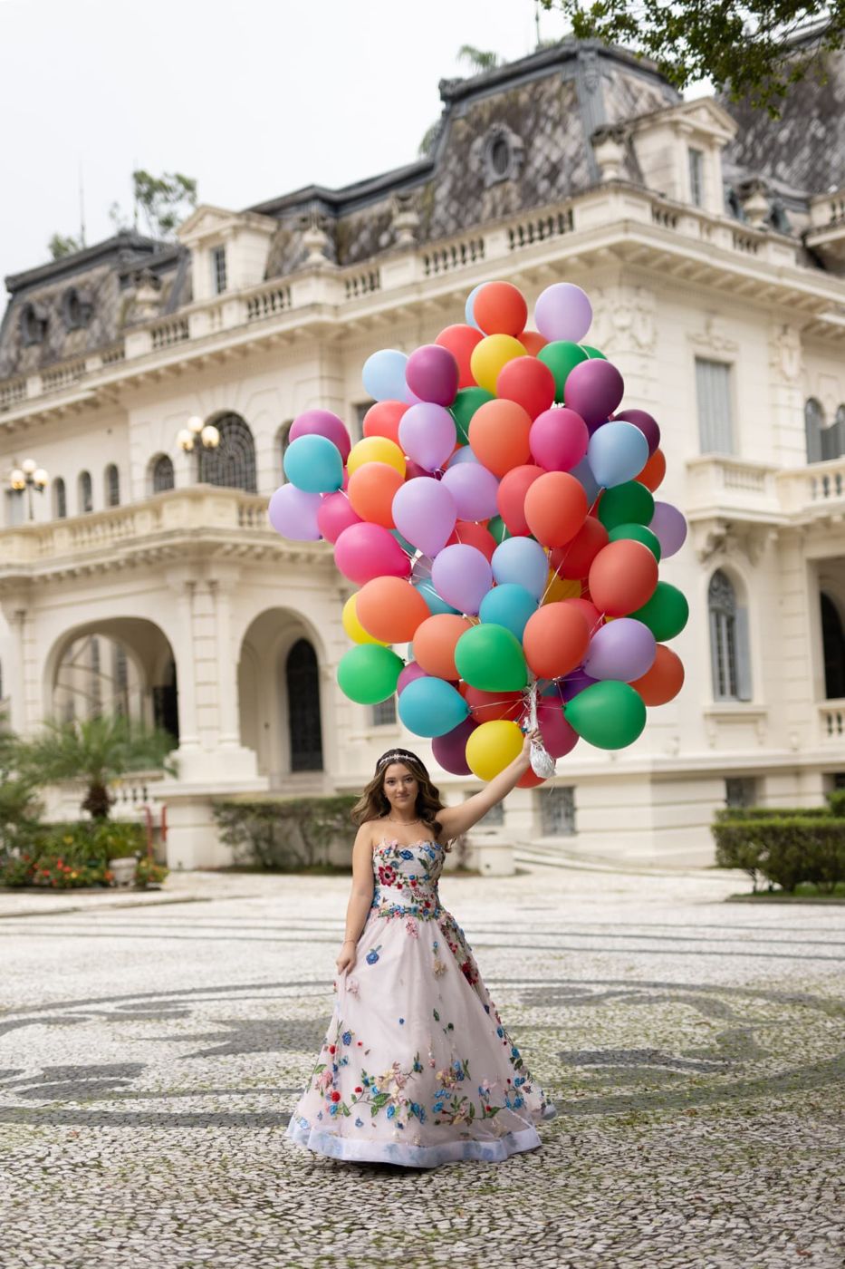 Debutante segurando buquê de balões coloridos em ensaio de festa de 15 anos