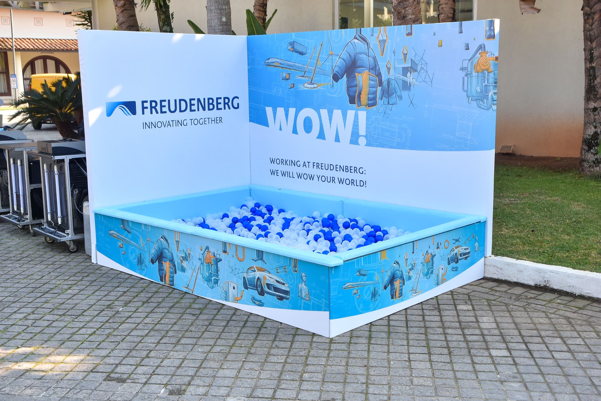 Ativação de marca com piscina de bolinhas e painel institucional em evento corporativo