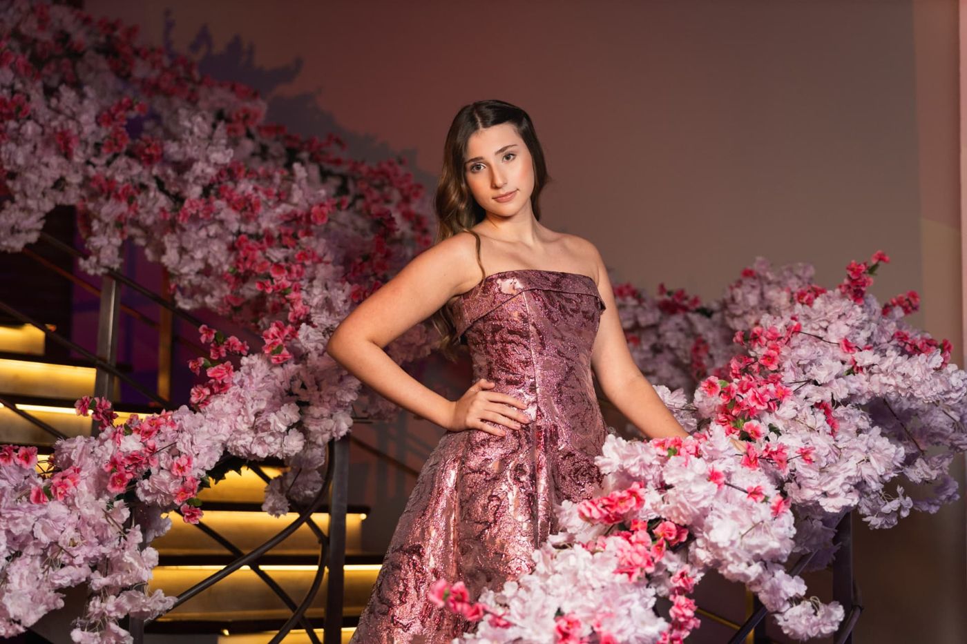 Debutante em vestido rosa entre flores de cerejeira em festa de 15 anos assessorada por Dani Baida