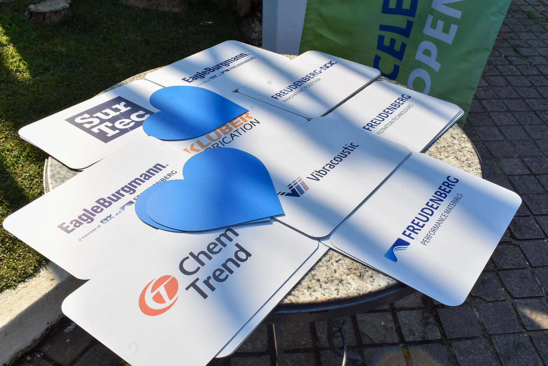 Placas com logotipos das marcas participantes preparadas para ativação em evento corporativo